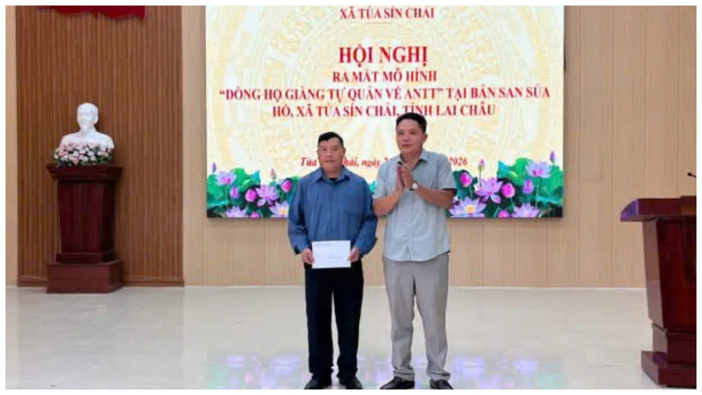 Đồng chí Phó bí thư thường trực Đảng uỷ xã trao quà cho đại diện dòng họ