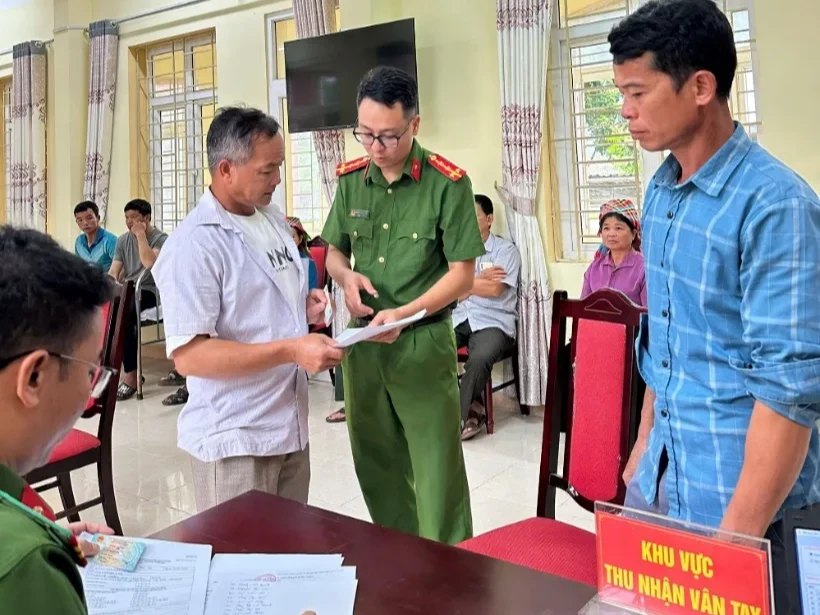 Cán bộ Công an xã hướng dẫn người dân làm thủ tục