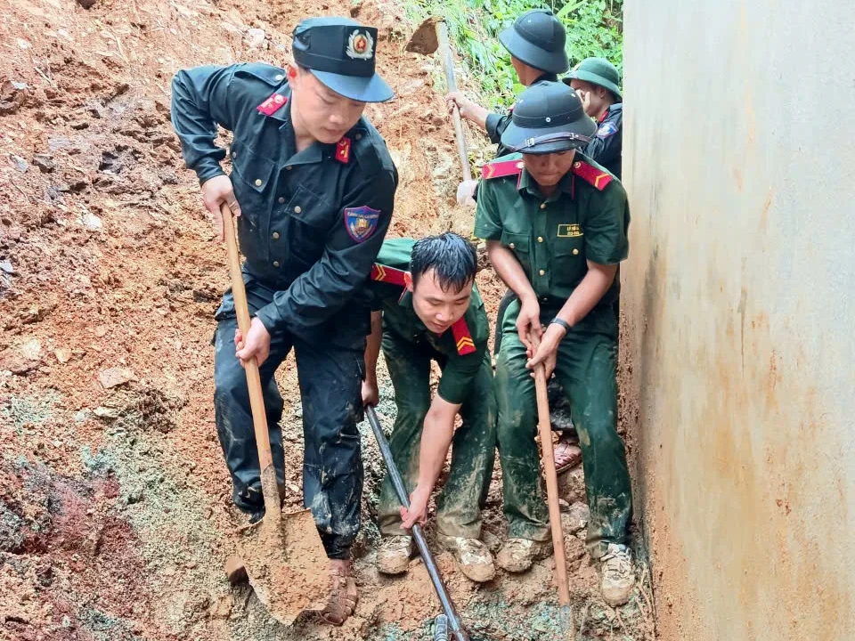 Đồng chí Trưởng phân trại tạm giam trực tiếp cùng Cán bộ chiến sĩ Phân trại tạm giam Mường Tè di chuyển khối lượng lớn đất đá sau nhà chị Chớn tại điểm sạt lở